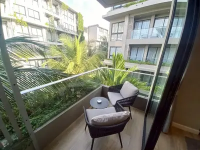 a balcony with two chairs and a table and a building at Amazing Apartment in Diamond Condominium, Bang Tao Beach in Bang Tao Beach