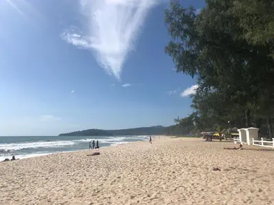 a group of people on a beach near the ocean at Amazing Apartment in Diamond Condominium, Bang Tao Beach in Bang Tao Beach