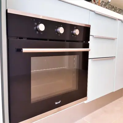 a black oven in a kitchen with white cabinets at Villa KHAO MANEE in Nai Yang Beach
