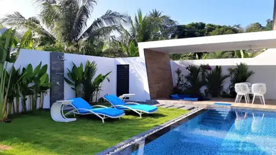 a patio with chairs and a swimming pool at Villa KHAO MANEE in Nai Yang Beach