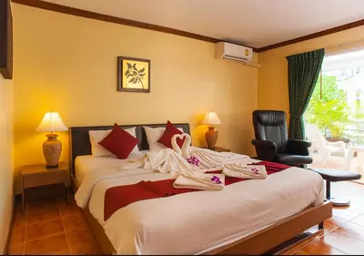 a hotel room with a bed with clothes on it at Patong Karlssons Hotel in Patong Beach