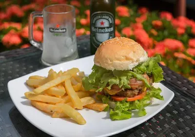 a white plate with a sandwich and french fries at Tropical Sands in Nai Harn Beach
