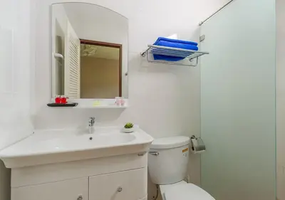 a white bathroom with a sink and a toilet at Tropical Sands in Nai Harn Beach