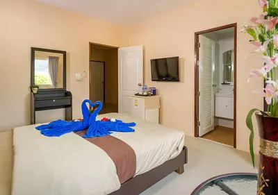 a bedroom with a bed with a blue ribbon on it at Tropical Sands in Nai Harn Beach