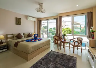 a bedroom with a bed and a table and chairs at Tropical Sands in Nai Harn Beach