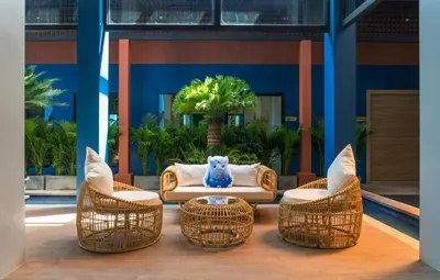 a patio with wicker chairs and a couch and a table at Anda Sea Tales Resort-SHA Plus in Ao Nang Beach
