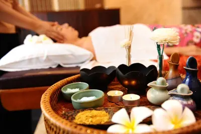 a woman laying in a bed with a tray of items at Anda Sea Tales Resort-SHA Plus in Ao Nang Beach