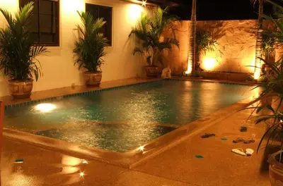 an empty swimming pool in a house with plants at Katanoi Resort in Kata Beach