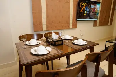 a dining room table with plates and wine glasses at Katanoi Resort in Kata Beach