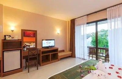 a bedroom with a desk and a computer in a room at Katanoi Resort in Kata Beach