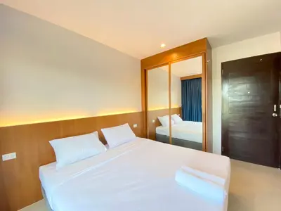 a bedroom with a white bed and a mirror at Pensiri House - SHA Extra Plus in Nai Yang Beach