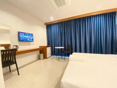 a hotel room with a bed and a desk at Pensiri House - SHA Extra Plus in Nai Yang Beach