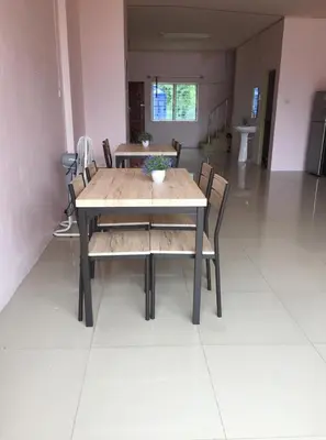 a wooden table and chairs in a room at Connexion in Ko Yao Noi