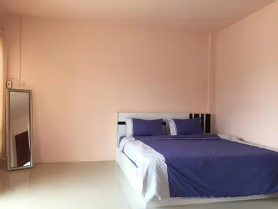 a bedroom with a bed with blue sheets and a mirror at Connexion in Ko Yao Noi