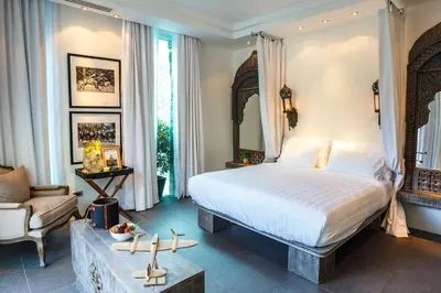 a bedroom with a large bed and a couch at Villa on The Rocks, 4 bedrooms, Phuket in Surin Beach