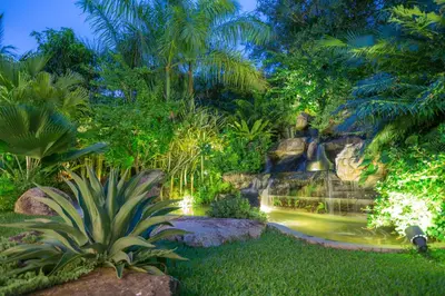 a waterfall in a tropical garden at night at Villa on The Rocks, 4 bedrooms, Phuket in Surin Beach