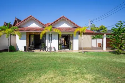 a house with a lawn in front of it at Villa Status in Nai Harn Beach