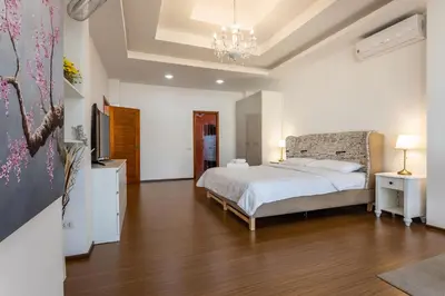 a bedroom with a bed and a television in it at Villa Status in Nai Harn Beach