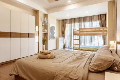a bedroom with a large bed with a teddy bear on it at Villa Status in Nai Harn Beach