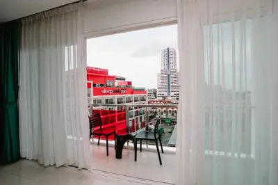 a room with a balcony with a table and chairs at SLEEP WITH ME HOTEL design hotel @ patong (SHA Plus+) in Patong Beach