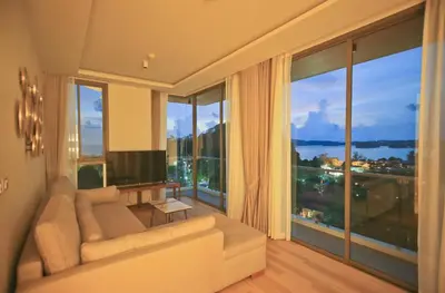 a living room with a couch and a large window at Rocco Aonang Krabi in Ao Nang Beach