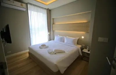 a bedroom with a bed with two towels on it at Rocco Aonang Krabi in Ao Nang Beach