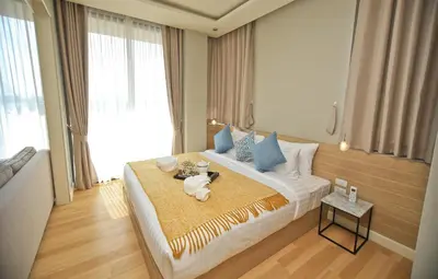 a hotel room with a large bed with a table at Rocco Aonang Krabi in Ao Nang Beach
