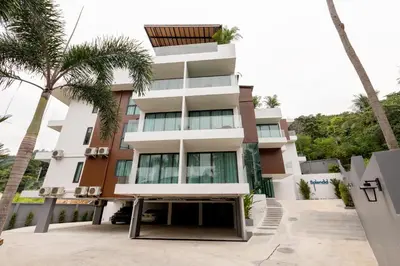 a building with palm trees in front of it at Splendid Sea View Resort in Kata Beach