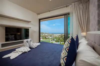 a bedroom with a blue bed with a large window at Splendid Sea View Resort in Kata Beach