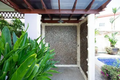 a pergola with a wall of rocks at Beautiful 5BR Villa Felicity, Pool & Garden, near Naiharn in Rawai Beach