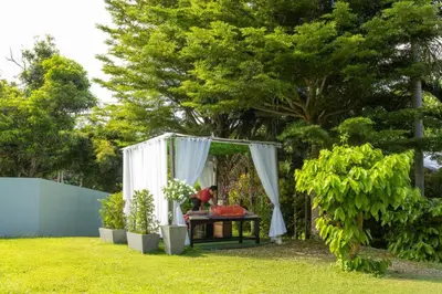 a garden with a table and a canopy at Harmony Naturist Resort Rawai Phuket 18yr minimum age only nudist nake d FKK in Rawai Beach