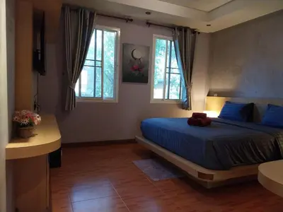 a bedroom with a blue bed and two windows at Harmony Naturist Resort Rawai Phuket 18yr minimum age only nudist nake d FKK in Rawai Beach