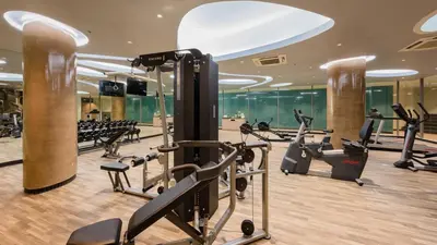 a gym with treadmills and ellipticals in a building at Oceanfront Beach Resort in Patong Beach