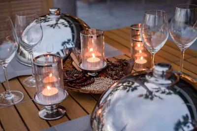 a wooden table with candles and glasses on it at Oceanfront Beach Resort in Patong Beach