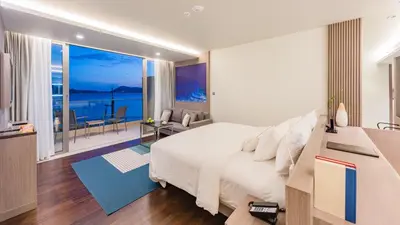 a bedroom with a bed and a view of the ocean at Oceanfront Beach Resort in Patong Beach