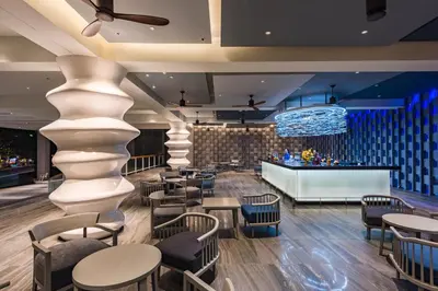 a lobby with tables and chairs and a bar at Oceanfront Beach Resort in Patong Beach