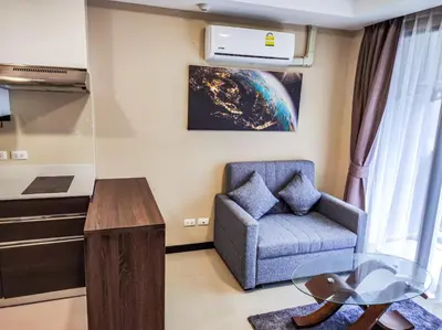 a living room with a chair and a table at MBC Mai Khao Beach Condotel LUXURY APARTMENTs in Phuket Town