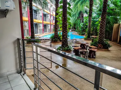 a resort with palm trees and tables and a pool at MBC Mai Khao Beach Condotel LUXURY APARTMENTs in Phuket Town