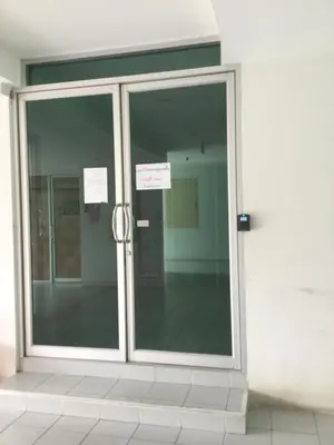 a glass door of a building with signs on it at Best Point Condominium Cape Panwa in Phuket Town