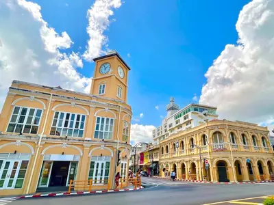 a building with a clock tower in the middle of a street at Best Point Condominium Cape Panwa in Phuket Town