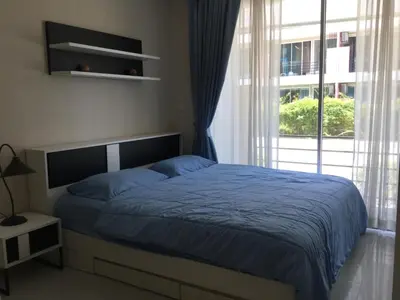 a bedroom with a bed and a large window at Best Point Condominium Cape Panwa in Phuket Town