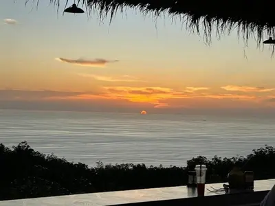 a sunset over the ocean with the sun in the distance at Best Point Condominium Cape Panwa in Phuket Town
