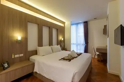 a hotel room with a large white bed and a desk at Icon Park Apartments - Kamala Beach in Kamala Beach