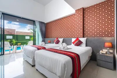 two beds in a room with red and white at The Thames Pool Access Resort & Villa - SHA Extra Plus in Chalong