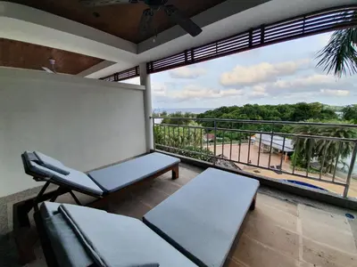 a balcony with benches and a view of a beach at Spacious apartment with Ocean view in Panwa in Phuket Town