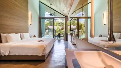 a bedroom with two beds and a bathtub and a tub at Island Escape Burasari in Phuket Town
