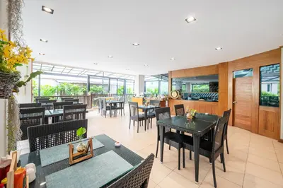 a restaurant with tables and chairs and a bar at Hotel COCO Phuket Bangtao Beach in Bang Tao Beach