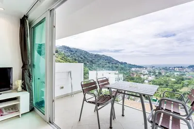 a balcony with a table and chairs and a view at Kata Ocean View condominium by Lofty in Kata Beach