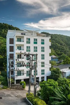 a large white building with trees in front of it at Kata Ocean View condominium by Lofty in Kata Beach