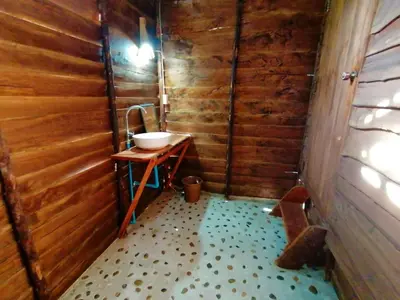 a bathroom with a sink in a wooden wall at Koom Kachanaan in Ban Nong Thale